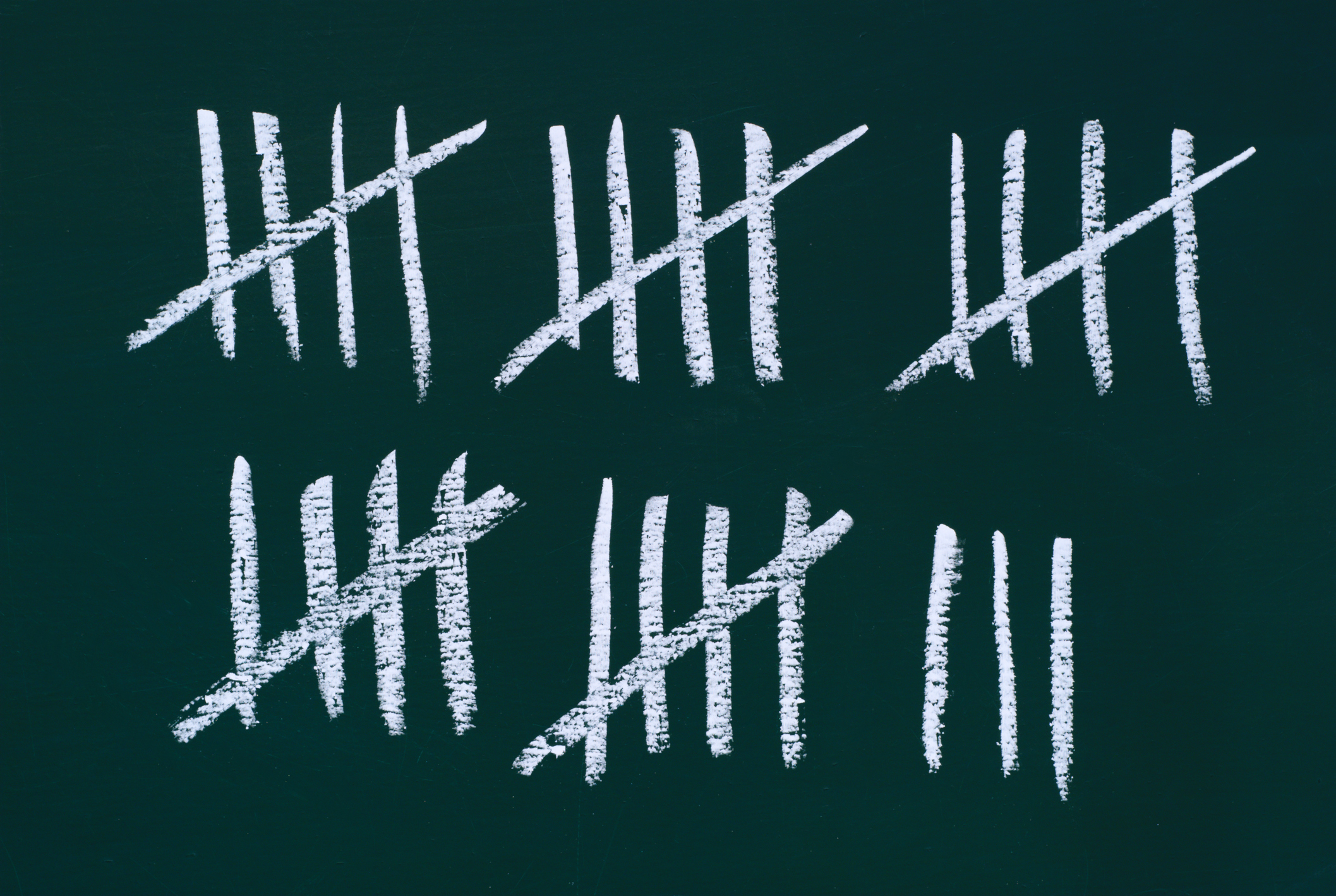 a chalkboard with marks of 5 that equal up to 28 marks total